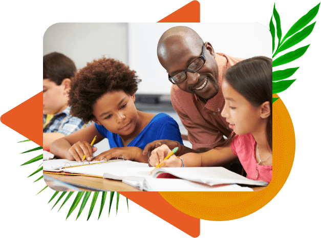 A black male teacher with glasses seated at a table between two middle-school-age female students writing in their notebooks