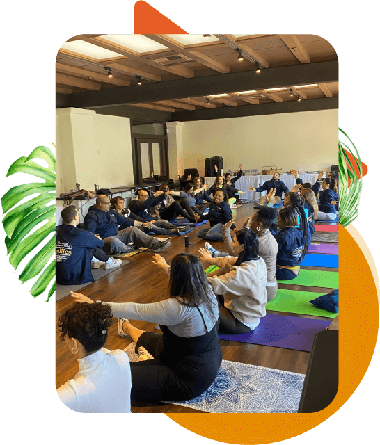 A diverse group of individuals lined up practicing yoga on yoga mats indoors